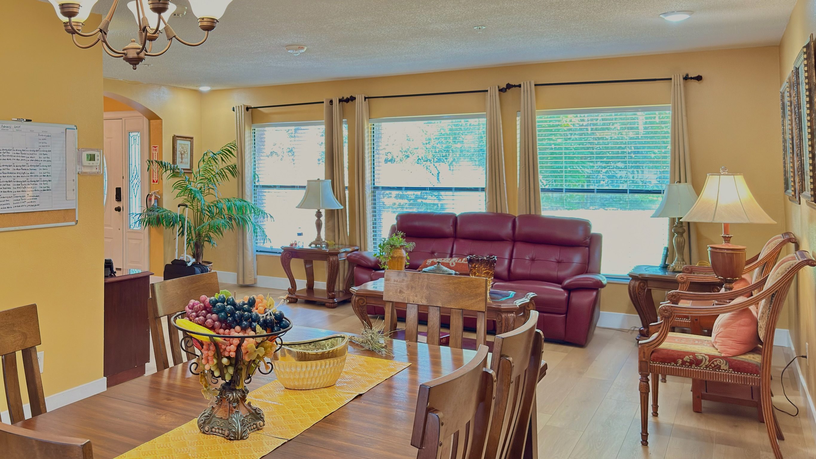 Open dining area with warm lighting, dining table set with fresh fruit, and view into the living room